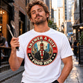 SKEWER A SUIT Cost of Living graphic tee, worn by a man holding barbecue tongs in a city laneway.